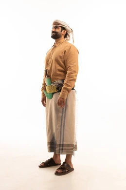 Preserving traditional attire, representing authentic Arab masculinity, expressions of cheerfulness and joy, looking at something above with gestures of self-confidence, a side portrait of a Yemeni Arab man wearing a shirt and a waist wrap with a turban and a jambiya standing upright, full body length, white background. Preserving traditional attire, representing authentic Arab masculinity, expressions of cheerfulness and joy, looking at something above with gestures of self-confidence, a side portrait of a Yemeni Arab man wearing a shirt and a waist wrap with a turban and a jambiya standing upright, full body length, white background.