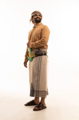 Representation of authentic Arab masculinity, preserving traditional attire, expressions of cheerfulness and joy, looking at something above with gestures of self-confidence, a portrait of a Yemeni Arab man wearing a shirt and izar with a turban and jambiya standing upright, full body length, white background.