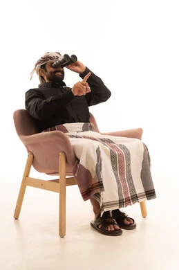 رؤية الاشياء البعيدة عبر التلسكوب، حب المغامرة والاستكشاف، نظرة ورؤية مستقبلية، بورتريه لرجل عربي يمني يرتدي القميص والازار مع العمامة يجلس على كرسي و ينظر من خلال المنظار ثنائي العينين يشير الى شيء ما، ايماءات السعادة و السرور، خلفية بيضاء