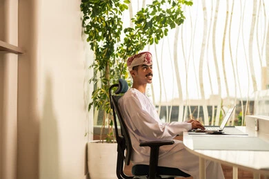 Remote work meeting, using computers and technology in the field of business, the concept of focus and precision in achievement, an Omani office profession and job, completing tasks in the office, an Arab Gulf Omani employee wearing a dishdasha and kumma using a laptop. Remote work meeting, using computers and technology in the field of business, the concept of focus and precision in achievement, an Omani office profession and job, completing tasks in the office, an Arab Gulf Omani employee wearing a dishdasha and kumma using a laptop.