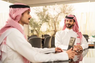 التحفيز المعنوي بين الزملاء, دمج التقنيات الحديثة فى العمل ،تبادل الخبرات و المعلومات لتحقيق الاهداف، تطوير و دراسة المشاريع الجديدة في الشركات السعودية ، ايماءات السعادة و السرور, مفهوم التعاون و العمل المشترك, زملاء عمل عرب  خليجيين سعوديين ويستخدمون الحاسوب المحمول والتابلت