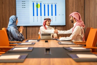شرح و تحليل الرسوم البيانية, إدارة و تقسيم المهام، فريق عمل عربي خليجي سعودي يقوم بإجراء اجتماع عمل داخل غرفة الاجتماعات في مقر الشركة، دمج الأجهزة التقنية الحديثة بالأعمال المكتبية، دراسة أوراق البيانات الإحصائية, تطوير المشاريع و الاستثمارات