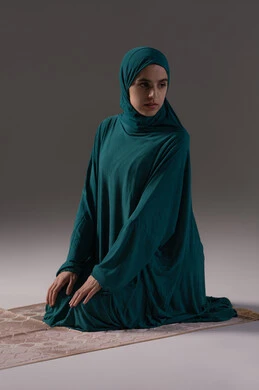 أداء الفرائض الدينية الإسلامية, إقامة الصلاة على وقتها, مفهوم أركان الإسلام، بورترية لامراه عربيه خليجيه سعودية تجلس على سجادة الصلاة تقوم بالتسليم في ختام الصلاة، الشعور بالخشوع والطمأنينة، العبادة والتقرب إلى الله، خلفية رمادية