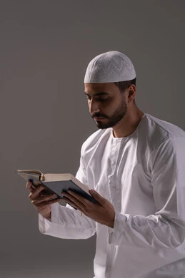 الطمأنينة القلبية أثناء العبادة، فهم معاني القرآن والتعمق في تدبره، بورتريه لرجل عربي خليجي إماراتي يرتدي الكندورة والقبعة البيضاء يقوم بقراءة المصحف الشريف، الإكثار من ذكر الله تعالى من خلال الاستغفار والدعاء، الاجتهاد في العبادة، التقرب الى الله في شهر رمضان، خلفية بيضاء