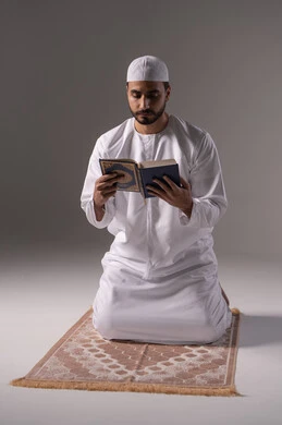استيعاب الدروس والعبر من آيات القرآن، الشعور بالخشوع والطمأنينة، بورتريه لرجل عربي خليجي إماراتي يرتدي الكندورة والقبعة البيضاء يجلس على سجادة الصلاة يقوم بقراءة المصحف الشريف، الإكثار من ذكر الله تعالى من خلال الاستغفار والدعاء، الاجتهاد في العبادة، التقرب الى الله في شهر رمضان، خلفية بيضاء