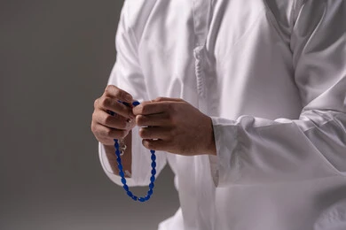 ترديد الأذكار والتسبيح وتمجيد الخالق، العبادة والطاعة والتقرب الى الله، بورترية مقرب ليد لشاب عربي خليجي اماراتي يرتدي الثوب الأبيض يمسك بيده سبحة من حبات من الخرز الزرقاء ، الاجتهاد في العبادات، خلفية رمادية ترديد الأذكار والتسبيح وتمجيد الخالق، العبادة والطاعة والتقرب الى الله، بورترية مقرب ليد لشاب عربي خليجي اماراتي يرتدي الثوب الأبيض يمسك بيده سبحة من حبات من الخرز الزرقاء ، الاجتهاد في العبادات، خلفية رمادية
