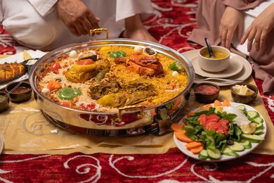 سفرة إفطار مليئة بأطباق من المأكولات والمقبلات الشهية في شهر رمضان المبارك, صورة مقربة لطاولة طعام متنوعة الأصناف في أحد المطاعم الاماراتية ، اجتماع العائلة حول مائدة الطعام، الولائم والعزائم في الامارات