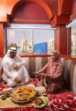 Preserving happy moments for memories, gestures of happiness and joy, an Emirati Gulf Arab family dressed in traditional attire sitting in a popular floor seating area around the dining table, the concept of family bonding, taking commemorative photos of food with a mobile phone. Preserving happy moments for memories, gestures of happiness and joy, an Emirati Gulf Arab family dressed in traditional attire sitting in a popular floor seating area around the dining table, the concept of family bonding, taking commemorative photos of food with a mobile phone.