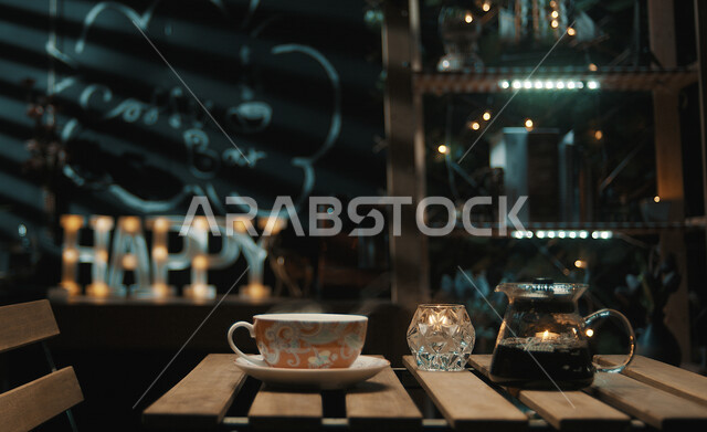 صورة لقهوة مقطرة مختصة على الطاولة في المقهى , أجواء هادئة وأضواء خافتة للإستمتاع في المقهى . 