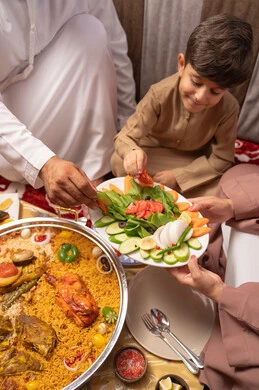سفرة إفطار مليئة بأطباق من المأكولات والمقبلات الشهية في شهر رمضان المبارك, صورة مقربة لطاولة طعام متنوعة الأصناف في أحد المطاعم الاماراتية، عائلة عربيه خليجيه اماراتية ترتدي الزي التقليدي تجلس فى مجلس ارضي شعبي العائلة حول مائدة الطعام