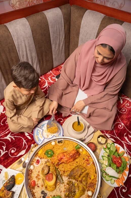 مفهوم النظام الغذائي الصحي، قضاء أوقات ممتعة مع الأبناء، امراه عربيه خليجيه اماراتية ترتدي العباءة و الحجاب تجلس فى مجلس ارضي شعبي برفقة ابنها يقومان بتناول افطار رمضان ، دور و حنان الأم في رعايه أبنائها مفهوم النظام الغذائي الصحي، قضاء أوقات ممتعة مع الأبناء، امراه عربيه خليجيه اماراتية ترتدي العباءة و الحجاب تجلس فى مجلس ارضي شعبي برفقة ابنها يقومان بتناول افطار رمضان ، دور و حنان الأم في رعايه أبنائها