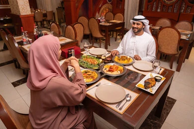 مائدة تجمع تشكيلة مختلفة من الأطعمة, رجل عربي خليجي إماراتي يرتدي الكندورة و الغترة البيضاء يجلس على المائدة يستعد لتناول فطار رمضان برفقة زوجته ، تعابير السعادة و السرور , مطاعم و كافيهات في الإمارات, قضاء الأوقات الممتعة في المطعم مائدة تجمع تشكيلة مختلفة من الأطعمة, رجل عربي خليجي إماراتي يرتدي الكندورة و الغترة البيضاء يجلس على المائدة يستعد لتناول فطار رمضان برفقة زوجته ، تعابير السعادة و السرور , مطاعم و كافيهات في الإمارات, قضاء الأوقات الممتعة في المطعم