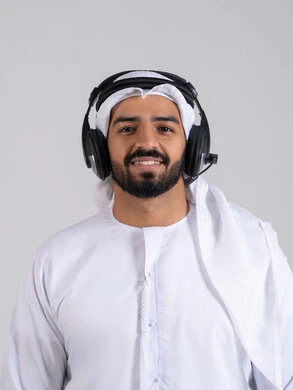 Communicating with customers to solve problems, integrating advanced technologies with work, looking at the camera with expressions of self-confidence, responding to inquiries and questions, a close-up portrait of a young Emirati Gulf Arab man wearing a kandura and ghutrah, wearing headphones, working in the customer service department, with a white background.