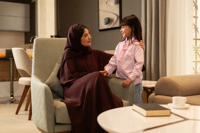 قضاء وقت ممتع مع البنات، مفهوم حنان الأمهات، تحمل المسؤولية والعناية بالأطفال،ام عربيه خليجيه سعودية محجبة ترتدي العباءة تمسك يد ابنتها بعطف وحب، مشاعر الأمومة والطفولة