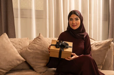 تقديم الهدايا في المناسبات السعيدة, الاحتفال بعيدالميلاد, التعبير عن المحبة والتقدير,امراة عربية خليجية سعودية محجبة ترتدي العباءة تمسك بيديها علبة هداية, النظر بإيماءات السعادة والسرور تقديم الهدايا في المناسبات السعيدة, الاحتفال بعيدالميلاد, التعبير عن المحبة والتقدير,امراة عربية خليجية سعودية محجبة ترتدي العباءة تمسك بيديها علبة هداية, النظر بإيماءات السعادة والسرور