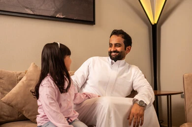 تقوية الروابط والعلاقات مع الأطفال بالعطف و الحنان، مفهوم الترابط الأسري بين أفراد العائلة، رجل عربي خليجي سعودي يرتدي الملابس التقليديه يجلس مع ابنته فى غرفه المعيشة، تعابير السعادة و السرور تقوية الروابط والعلاقات مع الأطفال بالعطف و الحنان، مفهوم الترابط الأسري بين أفراد العائلة، رجل عربي خليجي سعودي يرتدي الملابس التقليديه يجلس مع ابنته فى غرفه المعيشة، تعابير السعادة و السرور
