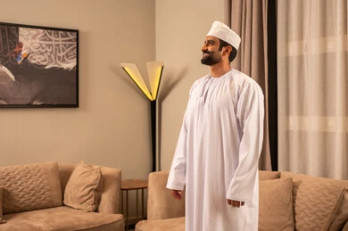 مفهوم الرجولة والثقة بالنفس، الاهتمام بالمظهر الخارجي والأناقة، رجل عربي خليجي عماني يرتدي الدشداشة و الكمة ينظر الى شيء ما ، الوقوف باستقامة وثبات