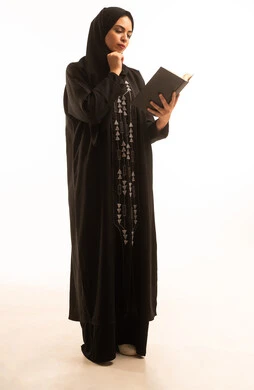 مفهوم الشغف بالقراءة, بورتريه لامرأة عربية خليجية سعودية ترتدي العباءة  السوداء والحجاب تمسك الكتاب، ممارسة هواية المطالعة,  مهنة ووظيفة نسائية مكتبية، خلفية بيضاء