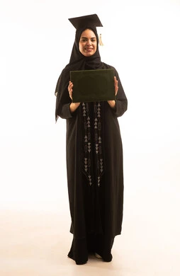 الشعور بالسرورو الفرح لتحقيق النجاح,  بورتريه لخريجة عربية خليجية سعودية محجبة ترتديعباءة سوداء والقبعة تحمل بيدها الشهادة، التفوق والتخرج من الجامعة، إيماءات السعادة بالوصول الى الحلم، خلفية بيضاء