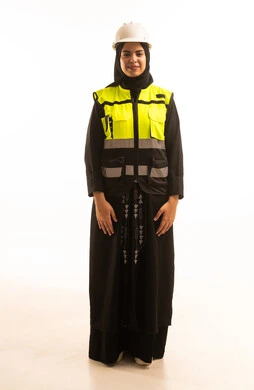 العمل في المجال الهندسي, بورتريه لمهندسة عربية خليجية سعودية محجبة ترتدي الخوذة وسترة الحماية الخاصة بالعمل مبتسمة وتنظر إلى الكاميرا، مفهوم الهندسة و الإنشاءات, كروما، خلفية بيضاء.