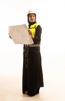 الهندسة والانشاء المعماري، بورتريه من الخلف لمهندسة عربية خليجية سعودية مبتسمة محجبة ترتدي الخوذة وسترة الحماية تمسك مخطط الإعمار, تقدم وتطور السعودية على يد نساء الوطن, الاهتمام بشؤون العمل, تدقيق مخطط الإنشاء, خلفية بيضاء