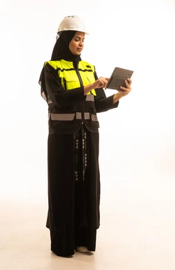 A portrait of a Saudi Gulf Arab female engineer wearing a jacket and safety helmet, monitoring the factory operations using a tablet device, relying on modern technology and engineering, studying the fundamentals of the project through the tablet application, full-body, white background.