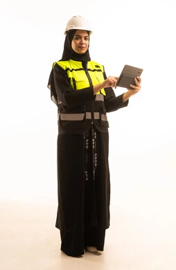 The adoption of modern technology and techniques in engineering, studying the fundamentals of the project through the use of a tablet, a portrait of a Saudi Gulf Arab engineer wearing a vest and safety helmet monitoring the progress of the factory using a tablet, full-body, white background.