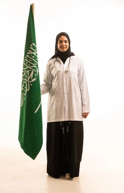 التباهي بإنجازات البلاد، بورتريه لطبيبة عربية خليجية سعودية ترتدي الحجاب مع المعطف الابيض والسماعة الطبية, ذكرى تأسيس الدولة السعودية الأولى 22 فبراير، النظرالى العلم بإيماءات الفخر, خلفية بيضاء