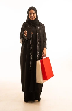 A black screen display, a portrait of a young Arab Gulf Saudi woman wearing a black abaya, holding a mobile phone and colorful shopping bags in her hand, full-body image, white background.