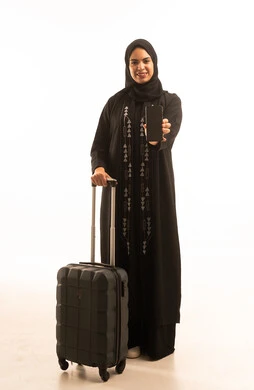 A black screen displayed on the phone, a portrait of a Saudi Gulf Arab woman wearing a black abaya holding a travel bag and a mobile phone, hotel booking through a travel app, chatting via social media, full-body image, white background. A black screen displayed on the phone, a portrait of a Saudi Gulf Arab woman wearing a black abaya holding a travel bag and a mobile phone, hotel booking through a travel app, chatting via social media, full-body image, white background.