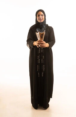 منتج محلي وطني، بورتريه لامرأة عربية خليجية سعودية محجبة ترتدي العباءة السوداء تمسك المبخرة التراثية المزخرفة بيدها تنظر الى الكاميرا، استخدام خشب العود للتطيب, أصالة العادات والتقاليد الخليجية, خلفية بيضاء