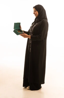 ذكرى تأسيس الدولة السعودية الاولى 22 فبراير، بورتريه من الجانب لشابة عربية خليجية سعودية ترتدي العباءة السوداء تنظر الى الكاميرا تحمل بيدها صندوق من خشب العود، يوم بدينا 1727 م، صورة الجسم بالطول الكامل، خلفية بيضاء