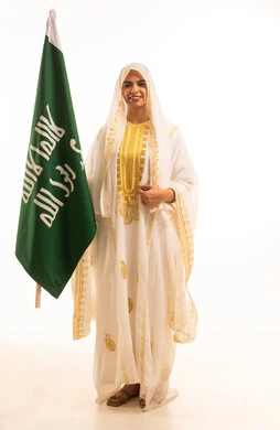 ارتداء زى المنطقة الشرقية، بورتريه لإمرأة عربية خليجية سعودية مبتسمة ترتدي الشيلة والنشل تحمل بيدها علم التأسيس، ذكرى تأسيس الدولة السعودية الأولى، يوم العلم السعودي11 مارس، يوم بدينا 1727 م، الاحتفال بالمناسبات والأعياد الوطنية الشعبية، خلفية بيضاء