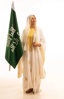 يوم بدينا 1727 م، ارتداء أزياء المنطقة الشرقية، بورتريه لإمرأة عربية خليجية سعودية مبتسمة ترتدي الشيلة والنشل تحمل بيدها علم التأسيس، ذكرى تأسيس الدولة السعودية الأولى، يوم العلم السعودي11 مارس، الاحتفال بالمناسبات والأعياد الوطنية الشعبية، خلفية بيضاء