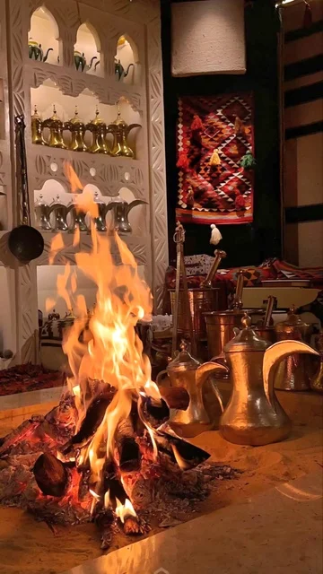 A youth outdoor picnic during the day, a traditional Arabic coffee pot with coffee cups, Saudi hospitality, spending enjoyable times with family and friends, in the heart of Saudi Arabia, tourist trip locations, traditional recreational sessions, enjoying local heritage and culture.