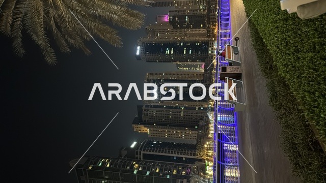 الواجهة البحرية على ساحل الخليج العربي، النمو والتطور العمراني للأبراج وناطحات السحاب المضيئية في وقت الليل في دولة الإمارات العربية المتحدة، معالم إمارة دبي السياحية المشهورة,  الفن الهندسي المعماري للمباني والمنشآت المطلة على المرفأ
