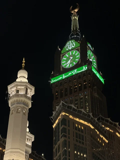 العبادة والتقرب إلى الله، معالم دينية اسلامية، صورة مقربة لبرج الساعة في مكة المكرمة في المملكة العربية السعودية ليلا،  بيت الله الحرام، أبراج الحرم المكي، مبنى برج الساعة الملكي المضيء بالمسجد الحرام، أطول برج ساعة في العالم