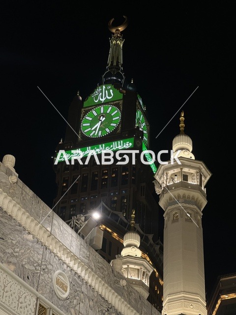 العبادة والتقرب إلى الله، معالم دينية اسلامية، صورة مقربة لبرج الساعة في مكة المكرمة في المملكة العربية السعودية ليلا،  بيت الله الحرام، أبراج الحرم المكي، مبنى برج الساعة الملكي المضيء بالمسجد الحرام، أطول برج ساعة في العالم