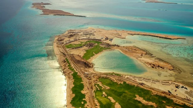 The turquoise waters of the Red Sea surround the island with white beaches, an aerial image of Sandala Island in the NEOM project in northwestern Saudi Arabia, attracting and drawing tourists from around the world, the modern design of Sandala resorts and yacht marinas, summer recreational activities, a natural landscape that combines luxury and tranquility.