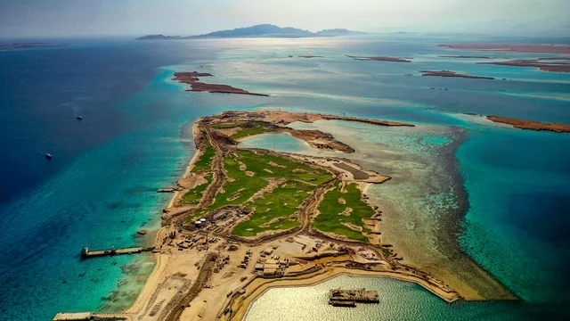 جذب واستقطاب السياح من انحاء العالم ، مياه البحر الأحمر الفيروزية تحيط بالجزيرة ذات الشواطئ البيضاء، صورة جوية لجزيرة سندالة في مشروع نيوم شمال غرب السعودية، التصميم العصري لمنتجعات سندالة ومراسي اليخوت، أنشطة صيفية ترفيهية، منظ طبيعي يجمع بين الفخامة والهدوء