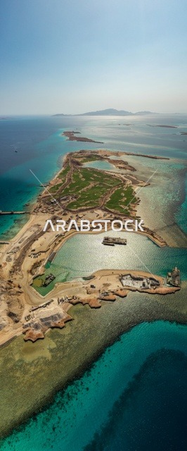 The modern design of Sandala resorts and yacht marinas attracts and draws tourists from around the world. The turquoise waters of the Red Sea surround the island with its white beaches. An aerial image of Sandala Island in the NEOM project in northwestern Saudi Arabia showcases summer recreational activities, a natural landscape that combines luxury and tranquility.