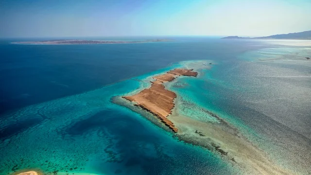 أنشطة صيفية ترفيهية، التصميم العصري لمنتجعات سندالة ومراسي اليخوت،  جذب واستقطاب السياح من انحاء العالم ، مياه البحر الأحمر الفيروزية تحيط بالجزيرة ذات الشواطئ البيضاء، صورة جوية لجزيرة سندالة في مشروع نيوم شمال غرب السعودية، منظ طبيعي يجمع بين الفخامة والهدوء