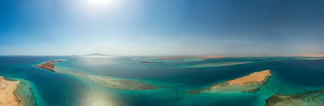 منظر طبيعي يجمع بين الفخامة والهدوء، أنشطة صيفية ترفيهية، التصميم العصري لمنتجعات سندالة ومراسي اليخوت،  جذب واستقطاب السياح من انحاء العالم ، مياه البحر الأحمر الفيروزية تحيط بالجزيرة ذات الشواطئ البيضاء، صورة جوية لجزيرة سندالة في مشروع نيوم شمال غرب السعودية