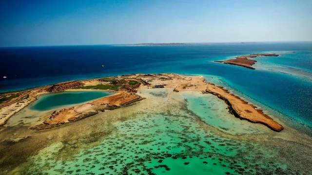 أماكن استقطاب السياح من انحاء العالم ،  طبيعة تجمع بين الفخامة والهدوء، أنشطة صيفية ترفيهية، التصميم العصري لمنتجعات سندالة ومراسي اليخوت، مياه البحر الأحمر الفيروزية تحيط بالجزيرة ذات الشواطئ البيضاء، صورة جوية لجزيرة سندالة في مشروع نيوم شمال غرب السعودية