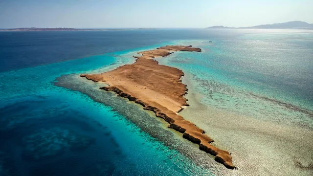 أماكن استقطاب السياح من انحاء العالم ،  طبيعة تجمع بين الفخامة والهدوء، أنشطة صيفية ترفيهية، التصميم العصري لمنتجعات سندالة ومراسي اليخوت، مياه البحر الأحمر الفيروزية تحيط بالجزيرة ذات الشواطئ البيضاء، صورة جوية لجزيرة سندالة في مشروع نيوم شمال غرب السعودية