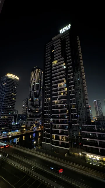 The growth and urban development of the illuminated towers of the Emirates at night, the buildings and commercial establishments in the United Arab Emirates, the architectural engineering art in the modern style of towers and skyscrapers, famous landmarks and tourist attractions in the city of Dubai, attracting and drawing tourists from around the world.