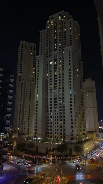 The growth and urban development of the illuminated towers of the Emirates at night, the buildings and commercial establishments in the United Arab Emirates, the architectural engineering art in the modern style of towers and skyscrapers, famous landmarks and tourist attractions in the city of Dubai, attracting and drawing tourists from around the world.