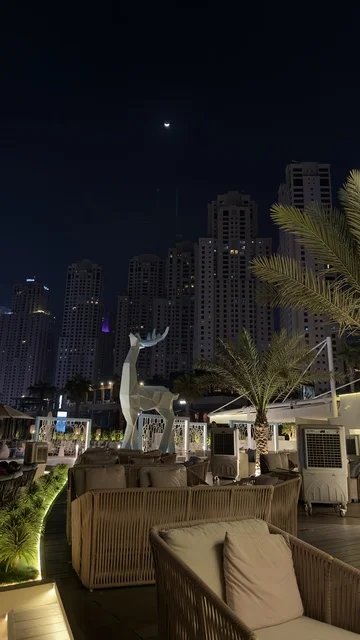 Commercial buildings and facilities in the United Arab Emirates, the growth and urban development of the brightly lit Emirates Towers at night, the architectural engineering art in the modern style of towers and skyscrapers, famous landmarks and tourist attractions in the city of Dubai, attracting and drawing tourists from around the world.