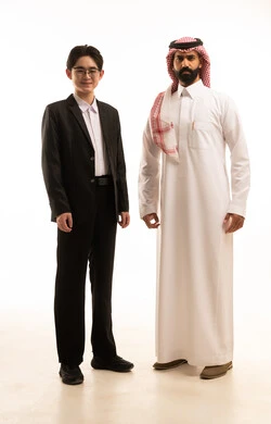 تبادل الخبرة والمعرفة بين البلاد، استضافة رجال الاعمال الأجانب في المملكة، بورتريه لرجل عربي خليجيسعودى يرتدى الثوب التقليدى والشماغ يقف بجانب شاب صينى يرتدي البدلة الرسمية ينظران الى الكاميرا بتعابيرالسرور، خلفية بيضاء