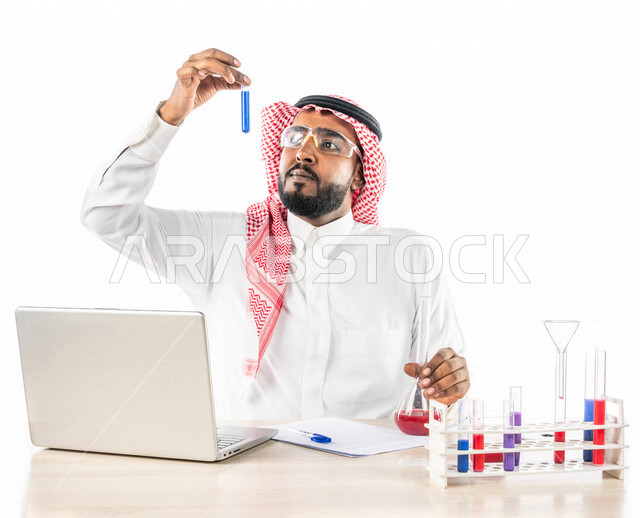 بورتريه لرجل خليجي سعودي ، بالزي السعودي التقليدي ، إستخدام جهاز الحاسوب المحمول، إستخدام انابيب الاختبار لإجراء التجارب، إجراء تجارب وتفاعلات كيميائية في المختبر، تجارب وأبحاث علمية، دراسات وتحاليل، خلفية بيضاء، مختبر ومعمل الكيمياء، البحث والتطوير